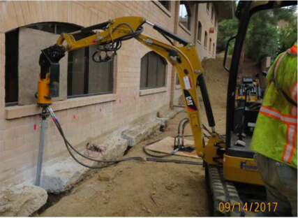 Drill attachment working beside a masonry building