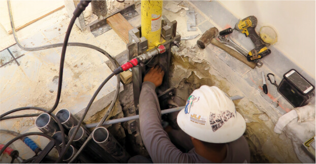Hydraulic pier press at a foundation wall